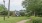 Path surrounded by trees with playground in background 