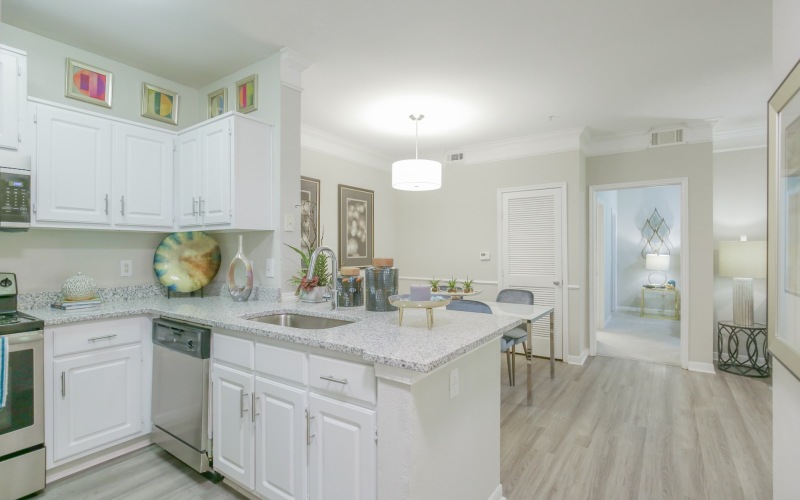 Styled kitchen with white cabinets opening up to dining room