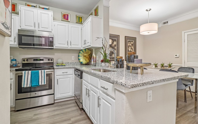 Styled kitchen with white cabinets opening up to dining room